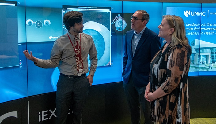 From left, Michael Hollins leads Brian Namey of the National Association of Counties  and Douglas County Commissioner Mary Ann Borgeson on a tour of the iEXCEL Visualization Hub.