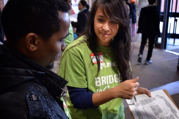 A Bridge to Care volunteer assists a refugee at a previous health fair.