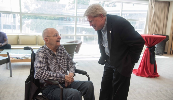 Former UNMC Chancellor Charles Andrews, M.D. (left), talks to Bob Bartee, vice chancellor for external relations, at a 2018 retirement party for Bruce Buehler, M.D., former director of the Munroe-Meyer Institute.