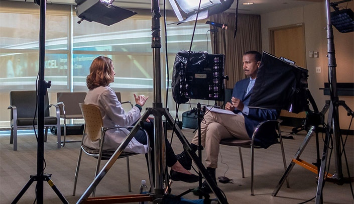 Angela Hewlett, M.D., left, speaks with Bill Whitaker during a taping for the CBS news program "60 Minutes."