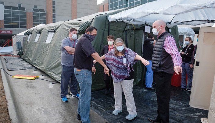 Staff members do a walkthrough of the surge tents set up outside the Emergency Services entrance on the Nebraska Medical Center campus.