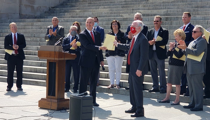 Governor Pete Ricketts and Jeffrey P. Gold, MD, chancellor of UNMC and the University of Nebraska at Omaha, display a copy of LB 1107.