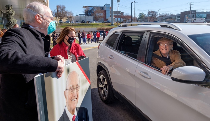 UNMC Chancellor Jeffrey P. Gold, MD and Kim Kanellis of the UNMC Stanley M. Truhlsen Eye Institute in Omaha, present Dr. Truhlsen with a giant birthday card on his 100th birthday.