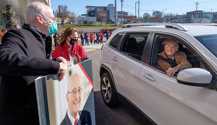 UNMC Chancellor Jeffrey P. Gold, MD, and Kim Kanellis of the Stanley M. Truhlsen Eye Institute in Omaha, present Dr. Truhlsen with a giant birthday card on his 100th birthday.