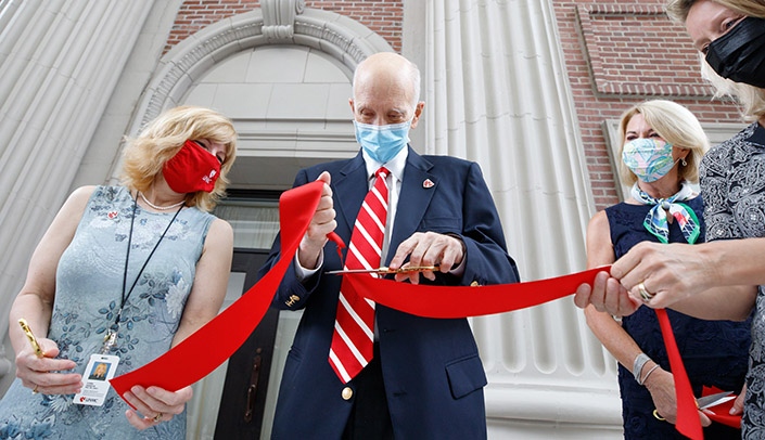 Robert Wigton, MD, cuts the ribbon on the new Wigton Heritage Center as, from left, Corrine Hansen, PhD, Omaha Mayor Jean Stothert and Amy Volk of the University of Nebraska Foundation look on.