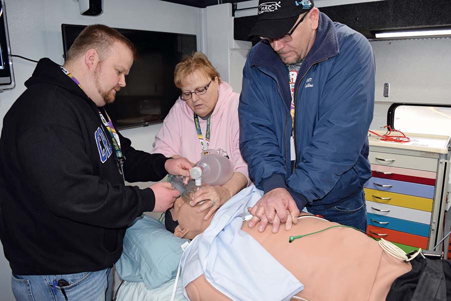 Volunteer emergency responders react to heart attack symptoms programmed into a manikin.