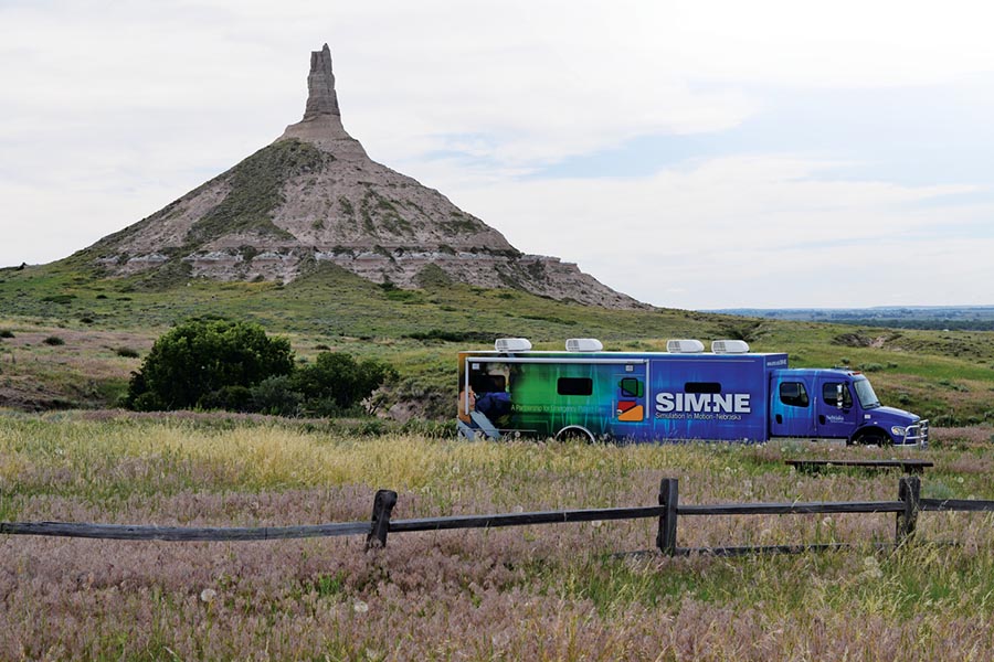 A Simulation in Motion-Nebraska truck sits on a gravel road with Chimney Rock in the background.