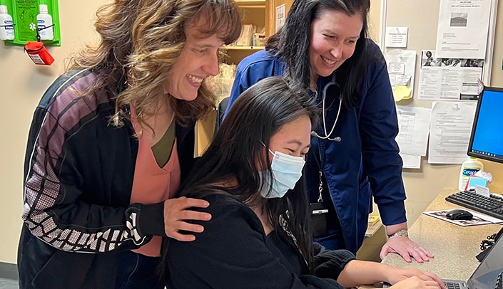 Terry Jo Crouse, director of health and wellness at Open Door Mission, and nurse Chris Hedger observe as Shawnalyn Sunagawa, Nebraska Medicine pharmacist resident, reviews and updates medication profiles in the electronic medical record.
