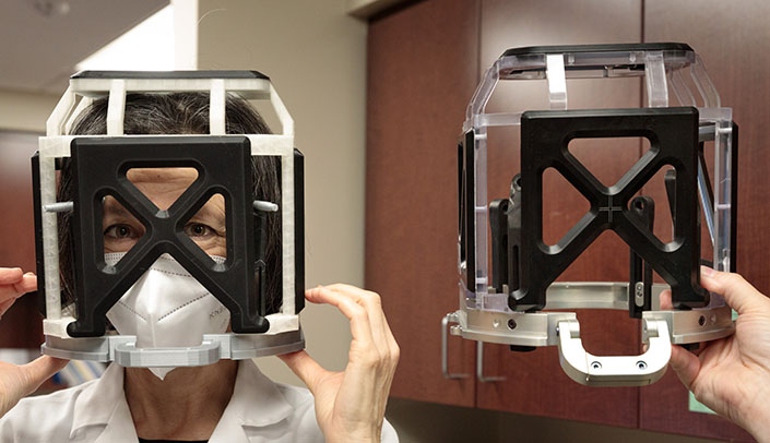 Aviva Abosch, MD, PhD, chair of the UNMC Department of Neurosurgery wears the 3D printed replica next to the stereotactic head frame device used in surgery. The 3D device is used to simulate the wear of the stereotactic head frame, which stabilizes the patient's head during certain surgeries that require that the patient be awake.
