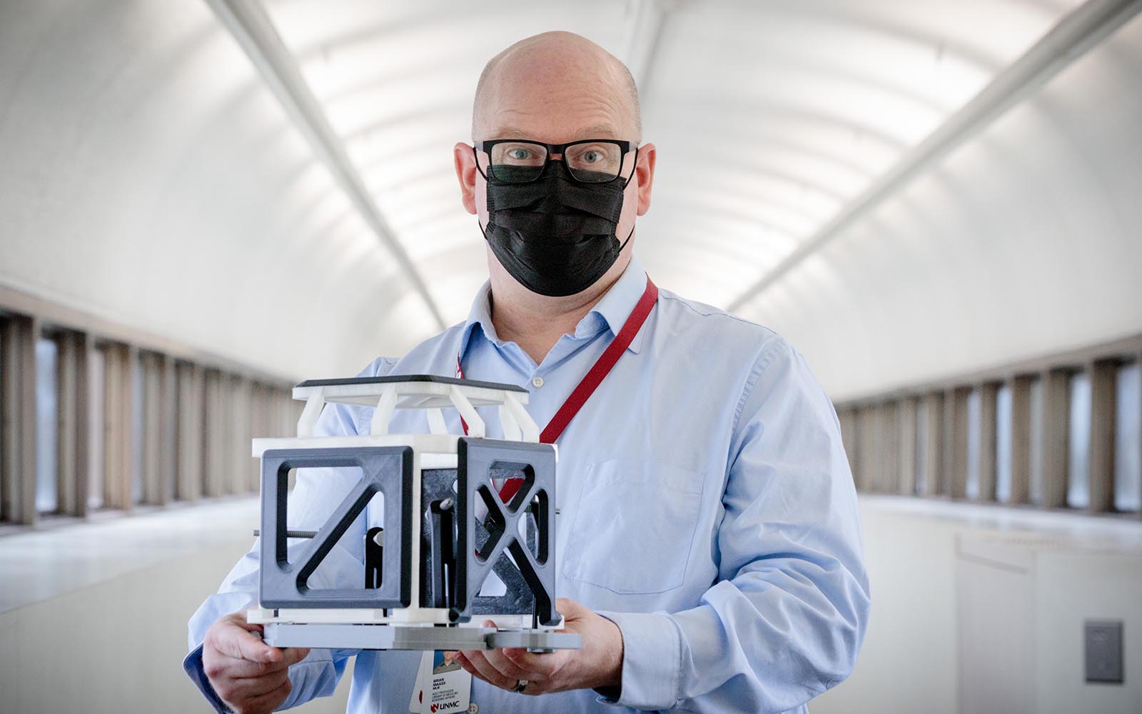 Brian Maass, assistant professor and digital technologies librarian at the McGoogan Health Sciences Library, displays the 3D printed replica of the stereotactic head from and fiducial localizer box, to be used to help patients overcome anxiety as they prepared for deep-brain stimulation surgery.