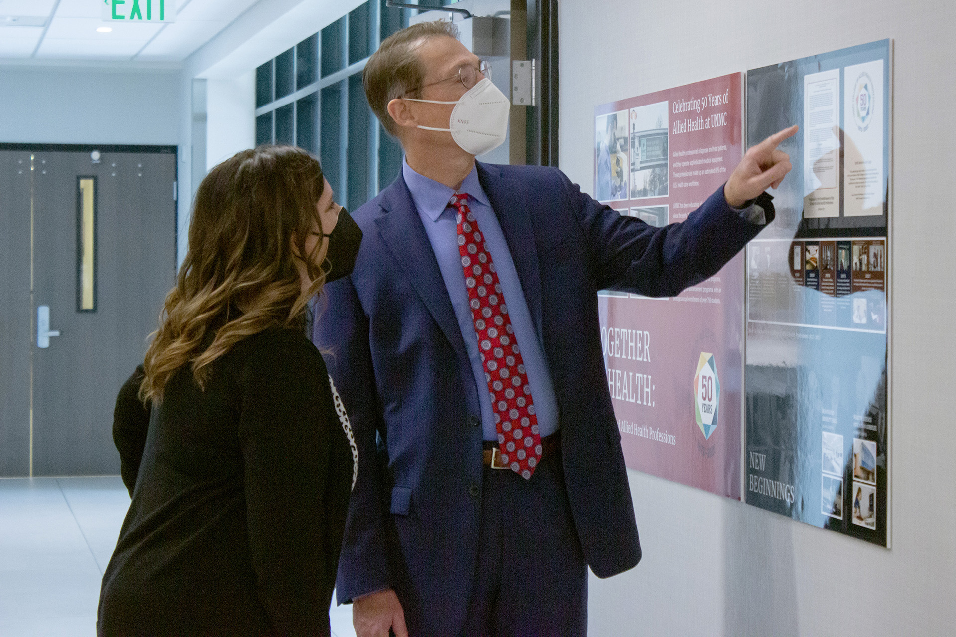 Dean Kyle Meyer&comma; PhD&comma; and Tammy Webster&comma; PhD&comma; assistant dean for academic affairs in the UNMC College of Allied Health Professions&comma; view the 50th anniversary display in the Wigton Heritage Center of the history of the college&period;