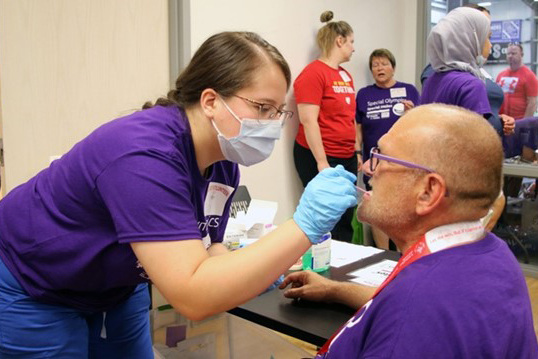 Chelsea Villa&comma; a fourth-year dental hygiene student&comma; applies fluoride varnish for a Special Olympics athlete&period;