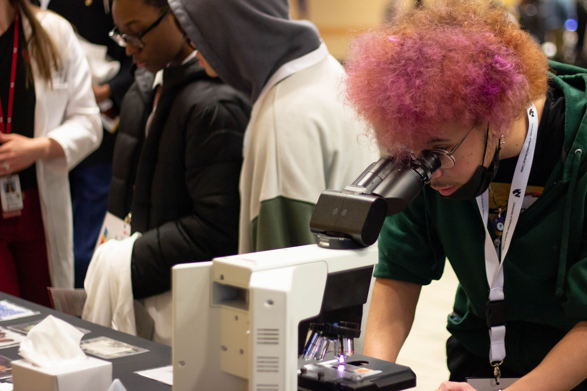 A high school student at the UNMC College of Allied Health Professions&apos; Backstage Pass event looks at cells through the microscope at the diagnostic cytology booth&period;