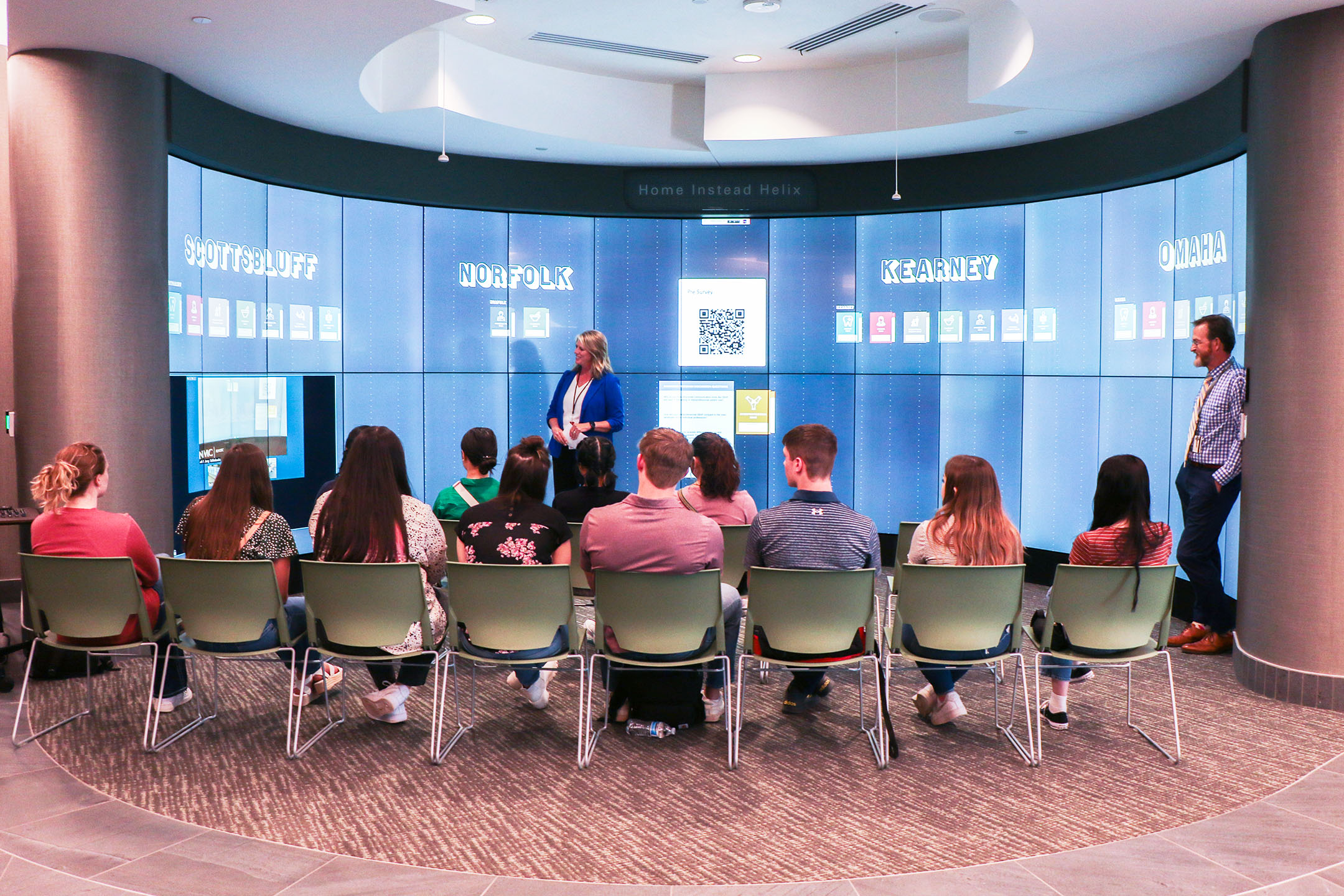 Kelli Schneegass&comma; rural health program specialist with the UNMC Office of Rural Health Initiatives&comma; discusses the iWall exercise with students from the UNMC Pathway Program participating from the UNMC Omaha campus at the Davis Global Center&period;