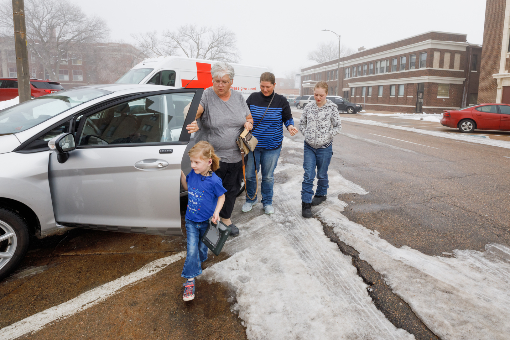 Five-year-old client exits family car, excited for her speech therapy session.