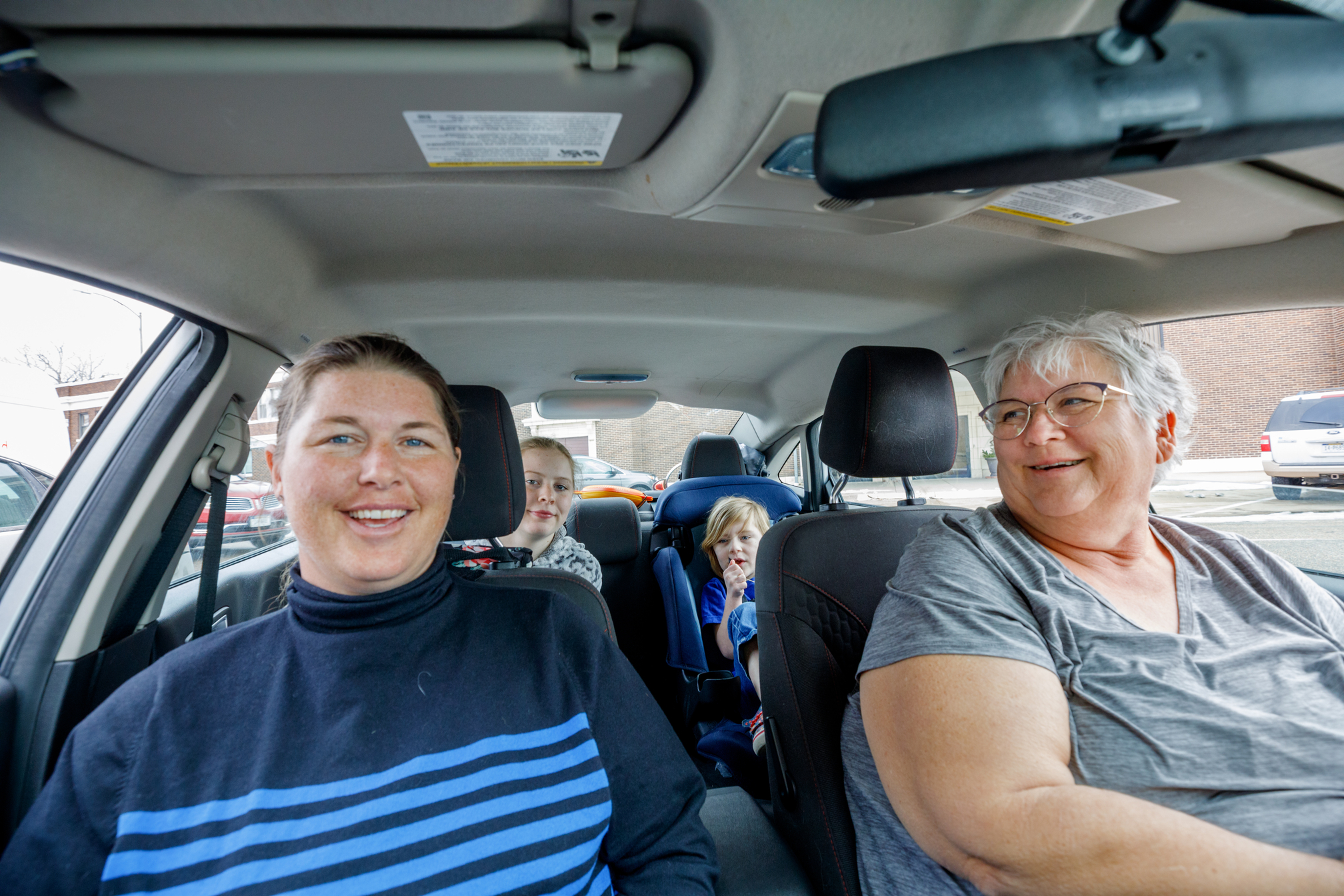 The family sits in their vehicle, ready for the drive home.