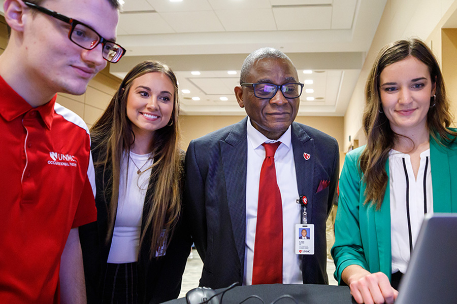 Student participants Josiah Heun&comma; Clancy Hesseltine and Lauren Wobken &lpar;from left to right&rpar; demonstrated their e-modules for Dele Davies&comma; MD&comma; senior vice chancellor for academic affairs&comma; at the 2023 E-Learning Showcase&period;