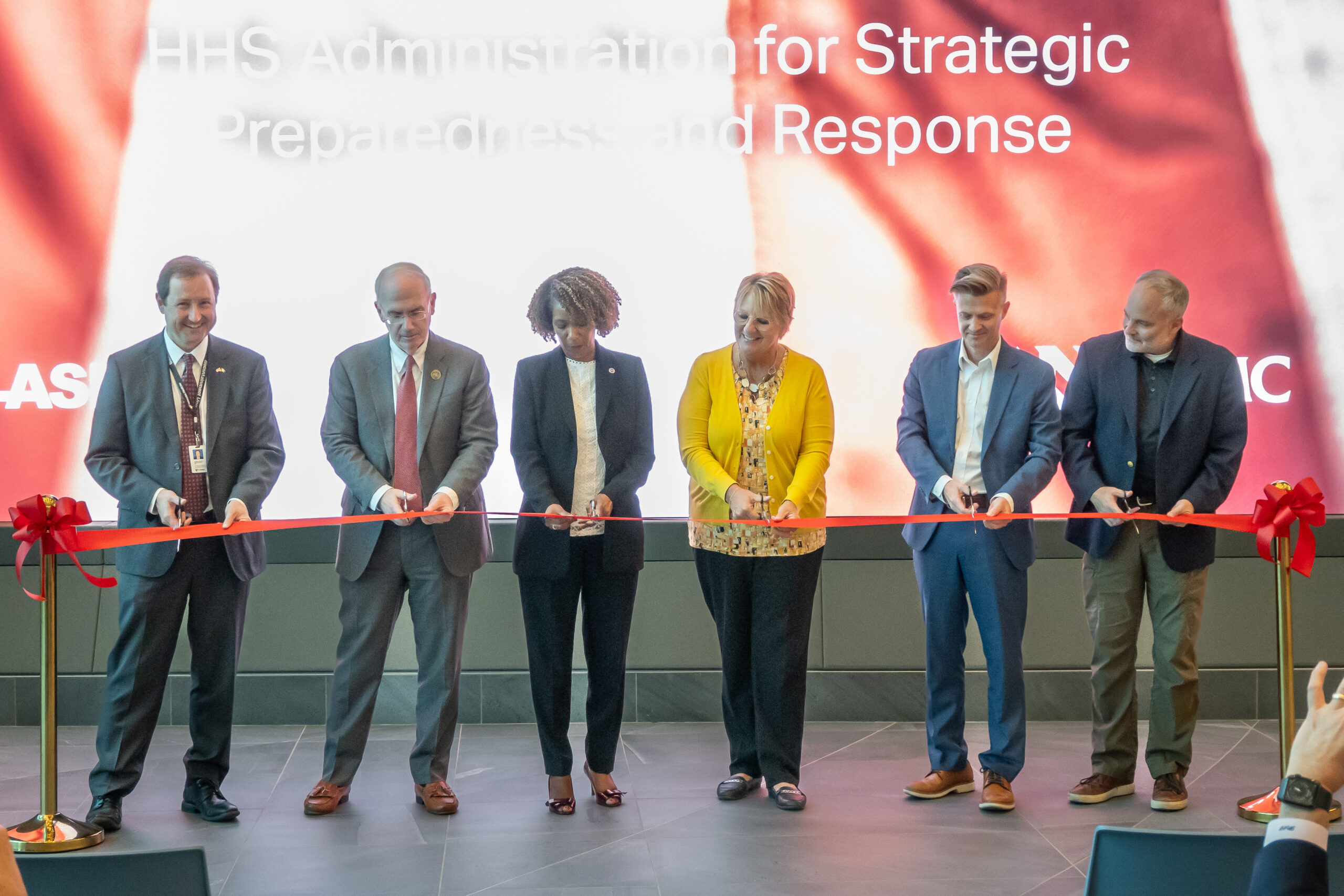 Leaders from UNMC&comma; the Global Center for Health Security and federal Administration for Strategic Preparedness and Response cut the ribbon on the national Training&comma; Simulation and Quarantine Center&period; From left are Chris Kratochvil&comma; MD&comma; UNMC Chancellor Jeffrey P&period; Gold&comma; MD&comma; Nikki Bratcher-Bowman of ASPR&comma; Shelly Schwedhelm&comma; John-Martin Lowe&comma; PhD&comma; and James Lawler&comma; MD&period;