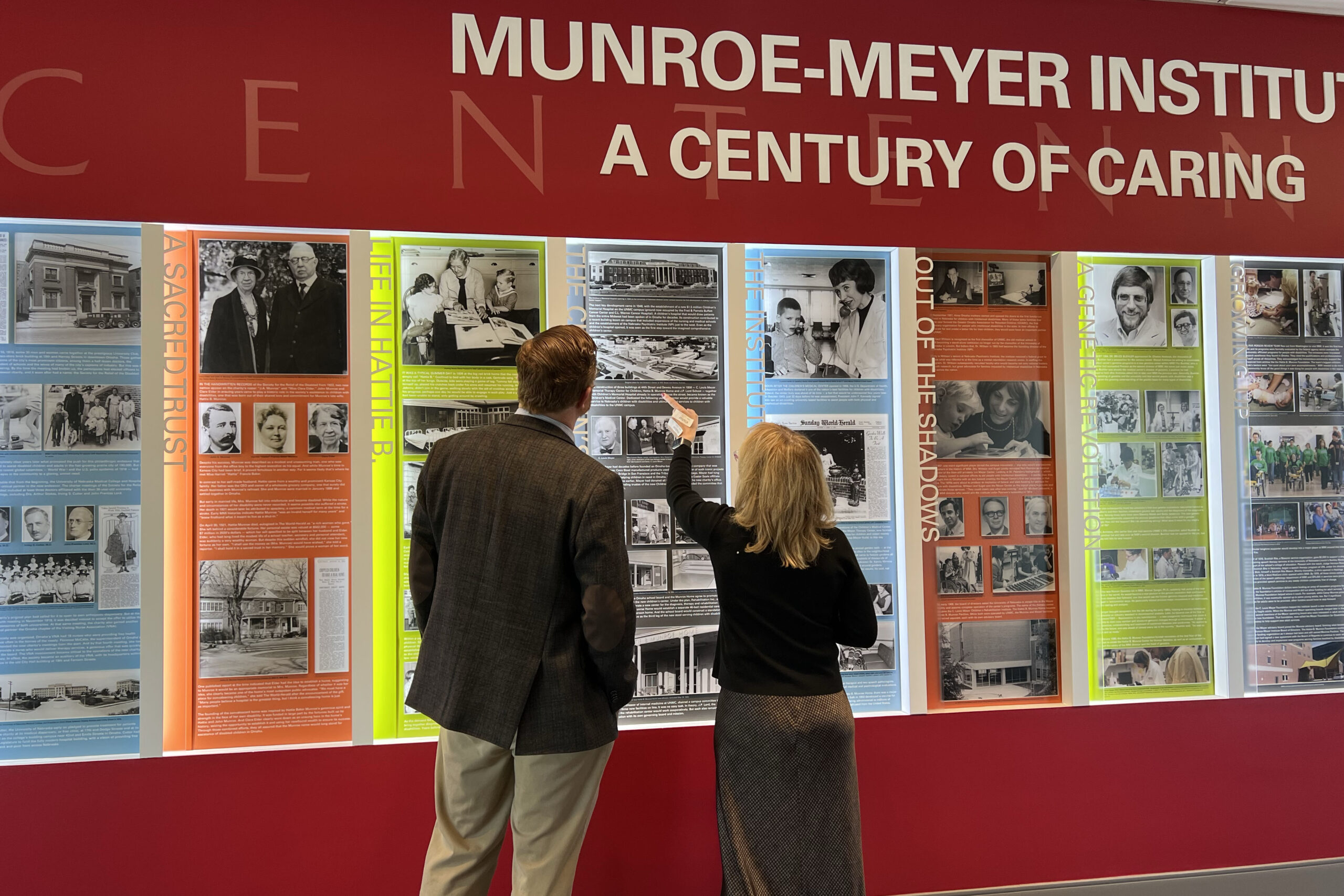 State Sen&period; John Cavanaugh&comma; left&comma; and Melonie Welsh&comma; MMI&apos;s director of community engagement&comma; look at the history wall at the Munroe-Meyer Institute&period;