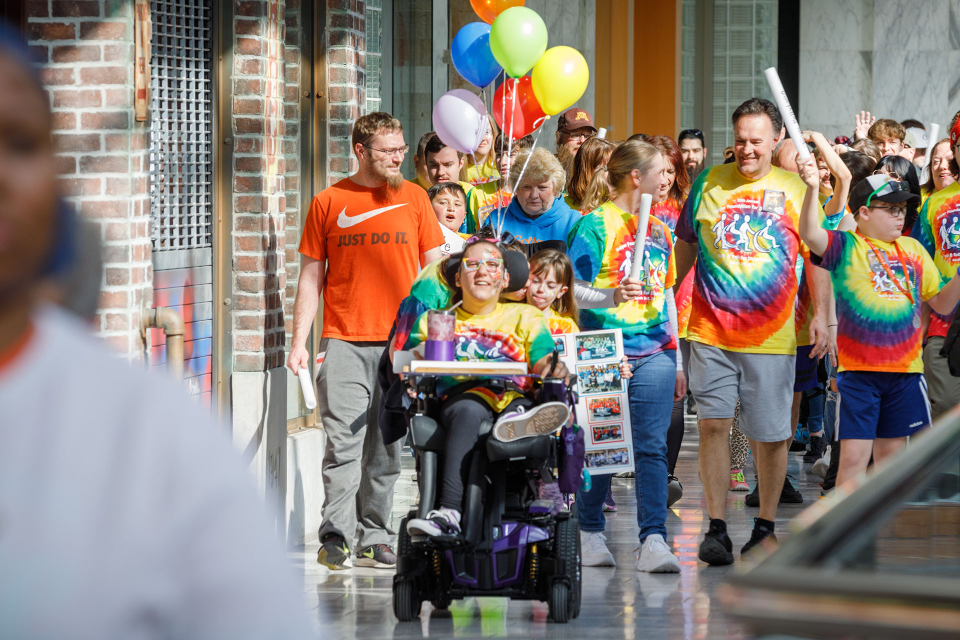 KellyLynn Wakehouse&comma; 32&comma; in wheelchair&comma; leads Team KellyLynn on a walk and roll around the upper level of Oak View Mall at the 20th annual Walk and Roll for Disabilities&period;