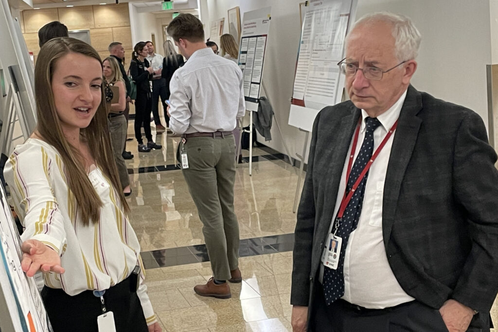 Kristina Sevcik, MD, a poster presentation awardee, discusses her poster -- “The Optimized Parameters of Red Blood Cell Exchange by Apheresis in Transfusion-Dependent Thalassemia, A Small Case Series" -- with UNMC College of Medicine Dean Bradley Britigan.