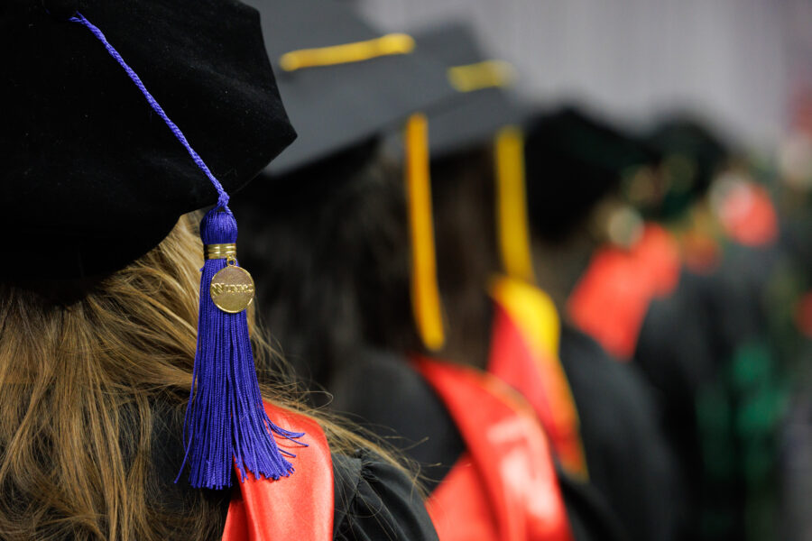 A row of UNMC graduates in their graduation gowns