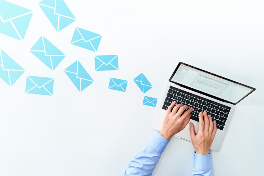 A person typing at a keyboard with email icons