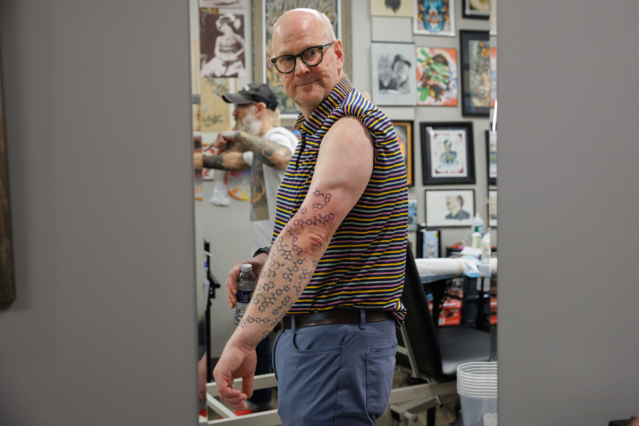 Dr. Hopkins looking at his tattooed arm in a mirror