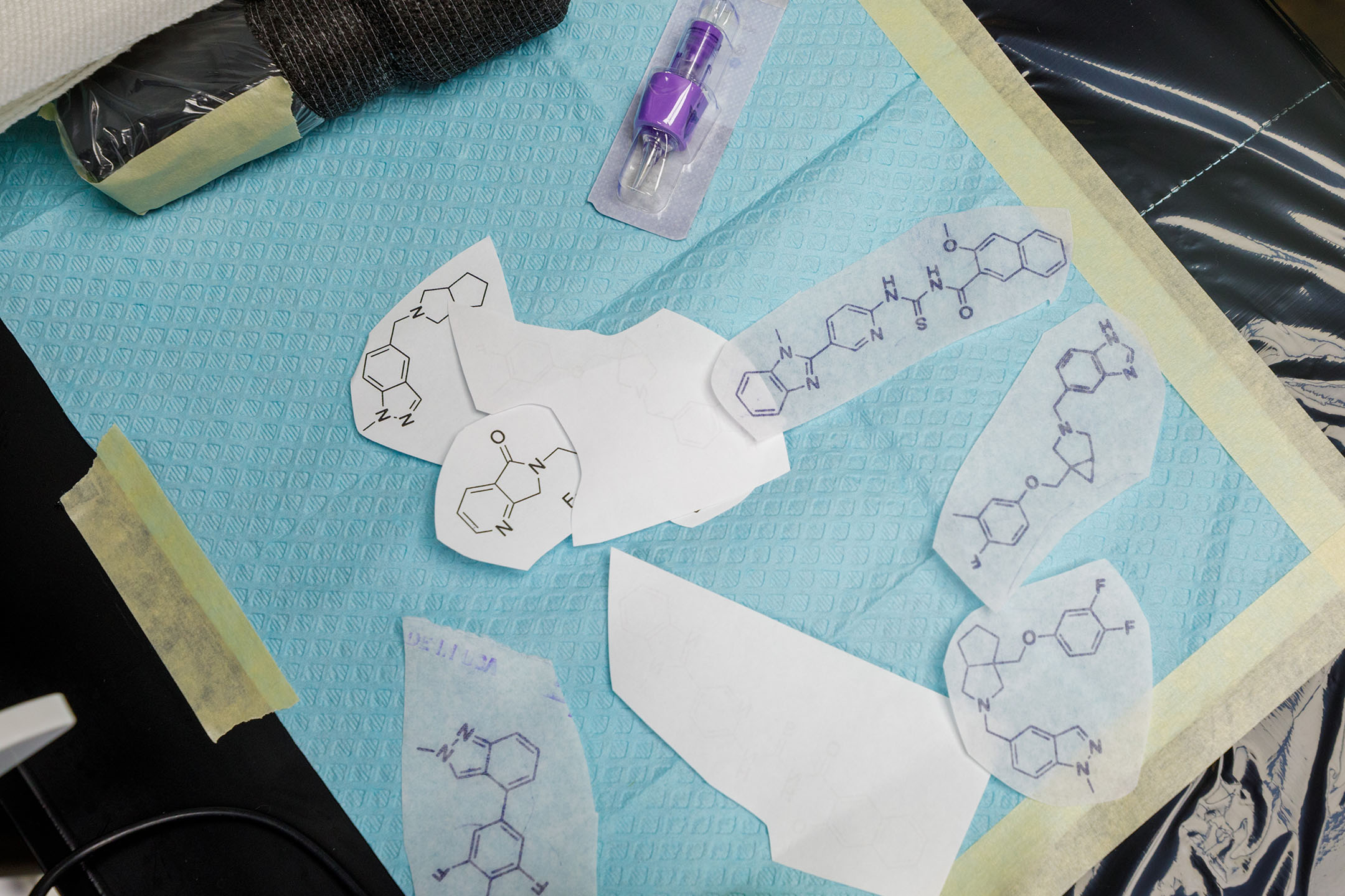 Paper inscriptions of the chemical compounds that will be tattooed on Corey Hopkins' arm