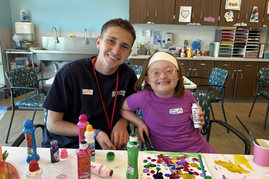 Finn Sully, a recreational technician at MMI, sits next to Luisa Brandt, 9. The two were camp buddies for the day.