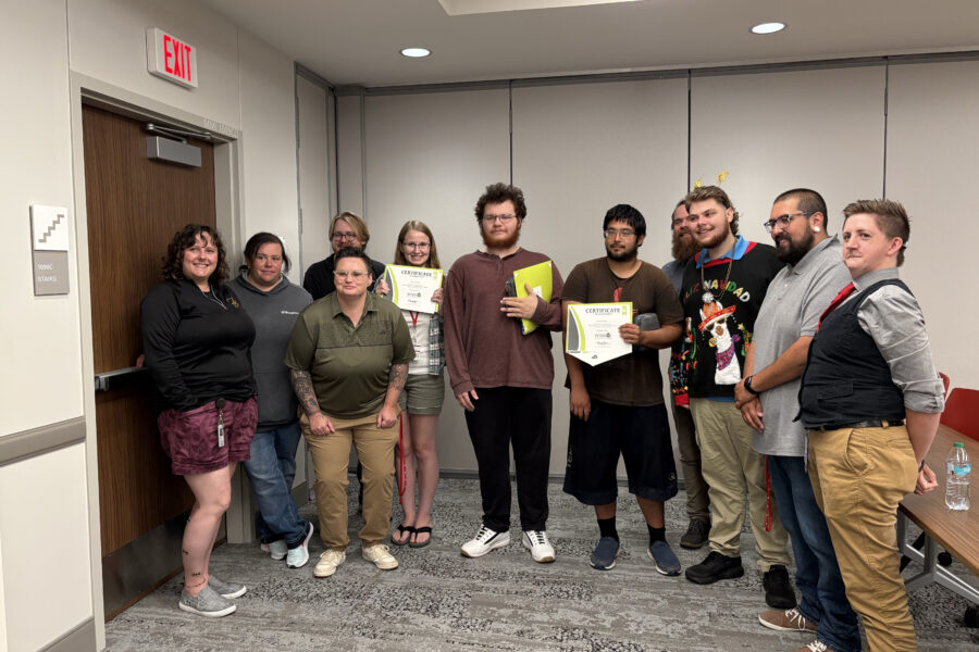 Graduates and program administrators pose for a photo after a ceremony celebrating their success in a joint program between MMI, Metropolitan Community College and an iFixAmerica training program administered by iFixOmaha.
