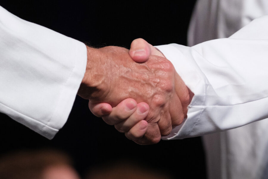 A handshake at the 2025 UNMC College of Medicine White Coat Ceremony