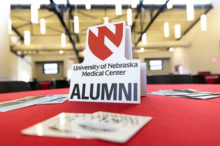 Sign at a table that says&comma; "University of Nebraska Medical Center ALUMNI"