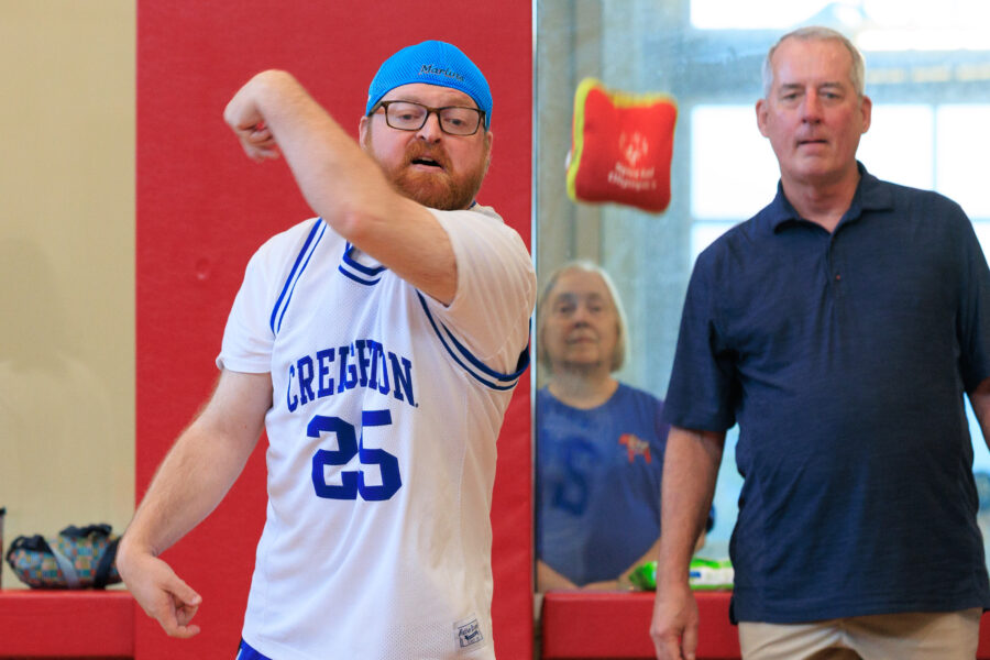 Matt Frohm launches a bean bag toward a cornhole board in the gym at the Munroe-Meyer Institute&period;