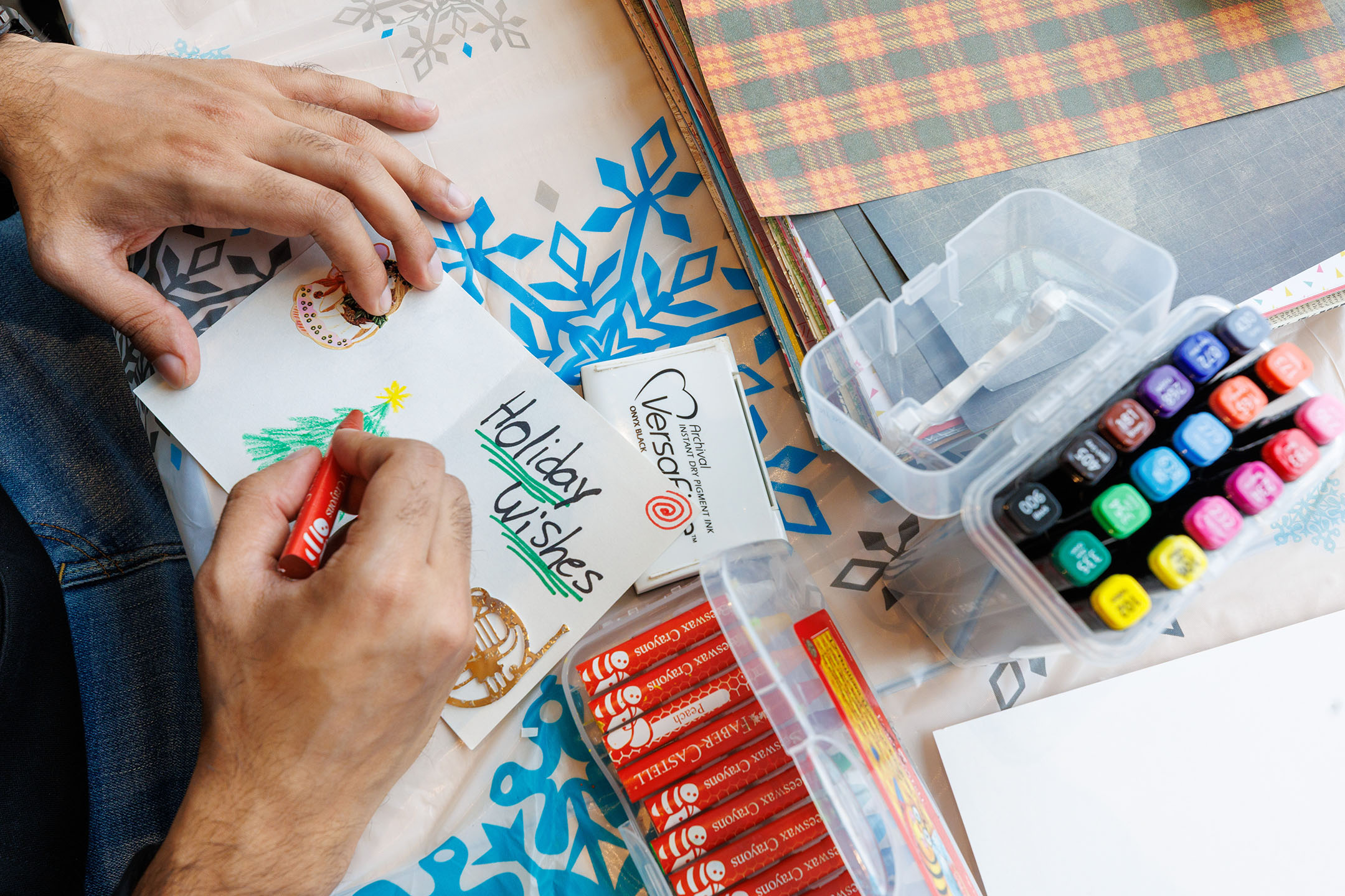 An image of someone making a craft card with the words Holiday Wishes