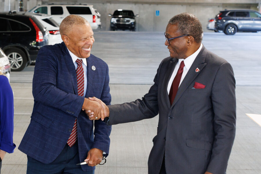 Interim Chancellor H&period; Dele Davies&comma; MD&comma; and Omaha Mayor John Ewing Jr&period; shake hands at a ribbon cutting in October opening the parking garage in EDGE District&period;