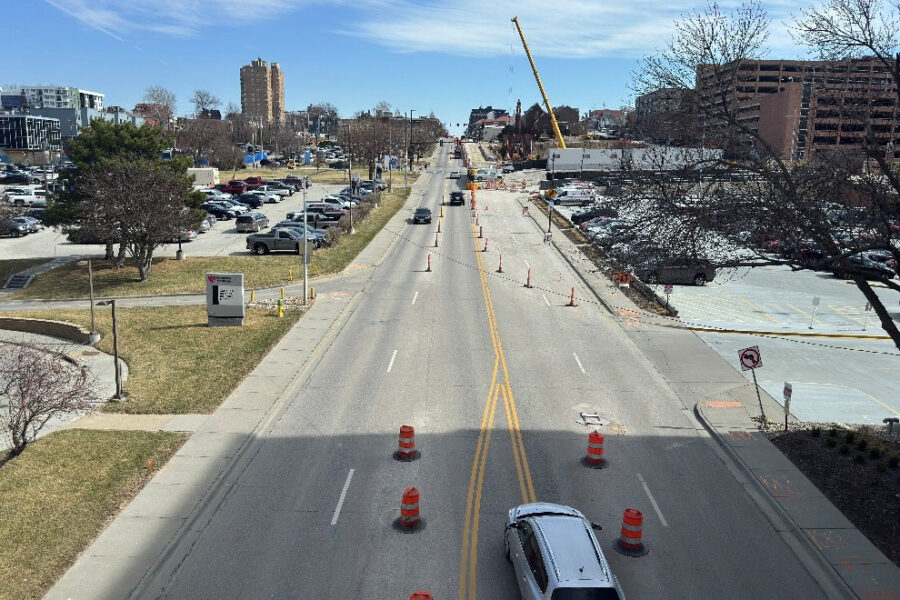 An aerial view down Farnam Street, with traffic cones in the street as cars drive by.