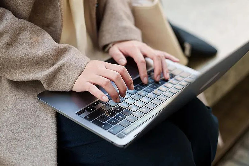 A woman typing on a laptop computer