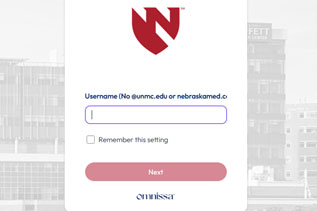 Login screen screenshot for a University of Nebraska Medical Center portal requiring username input without using @unmc.edu or @nebraskamed.com domains. Features a red shield logo at top, a username text box, a "Remember this setting" checkbox, and a pink "Next" button.