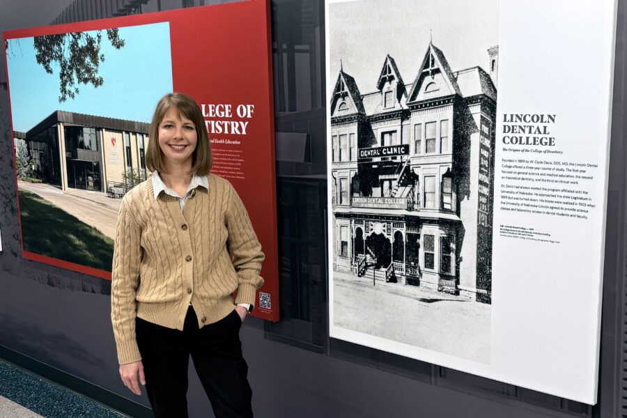 Emily Gish poses in front of the new UNMC College of Dentistry mural&comma; on display in the patient waiting area at the college&period;