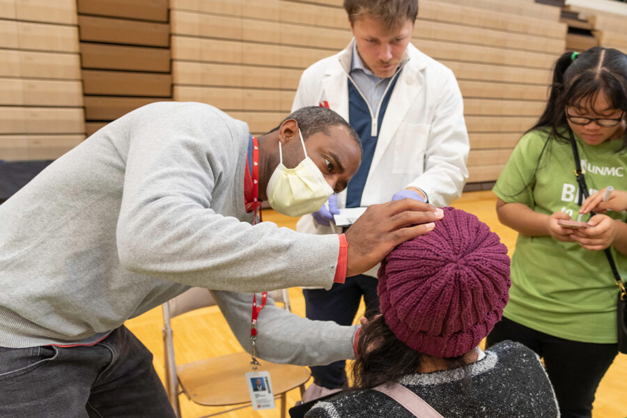 UNMC opthalmologist Brian Armstrong, MD, cares for a patient at a UNMC Bridge to Care clinic.