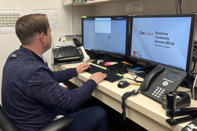 A UNMC IT worker handles OneChart duties at his work station.