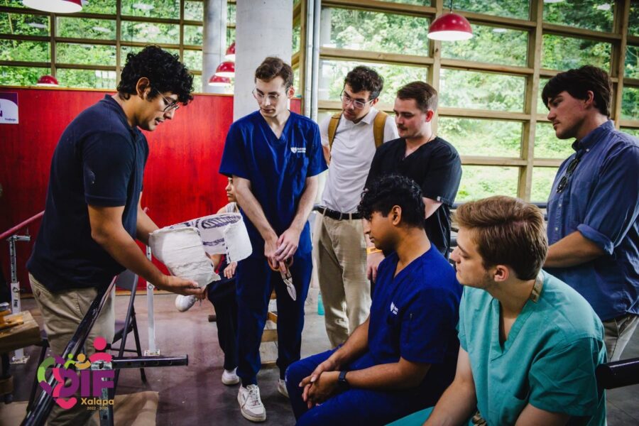 A DIF staff member shows students &lpar;standing left to right&colon; Elias Smith&comma; Caden Connealy&comma; Nolan Zeger&comma; Mitchell Blaine&semi; sitting left to right&colon; Eben Samuel & Jacob Rademacher&rpar; a plaster mold that was created&period; He will use this mold to design the prosthetic for this patient&period;