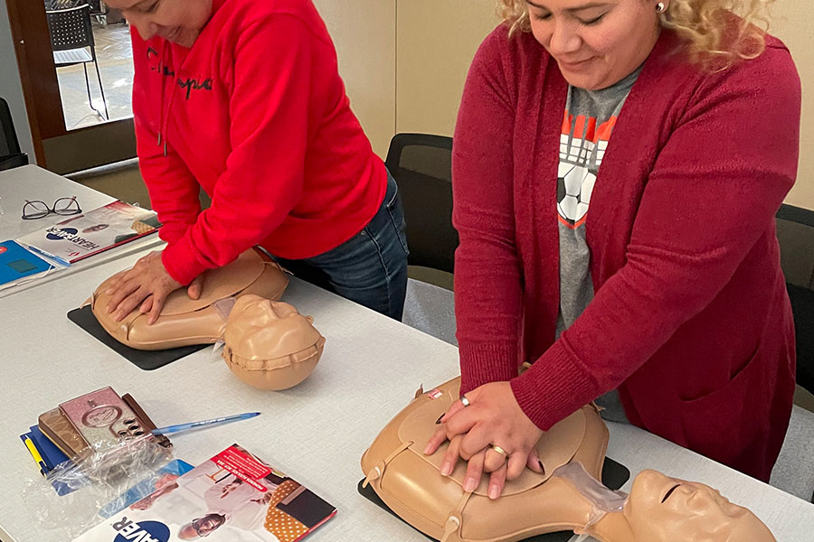 Two CRP and first aid certification students practicing CRP on a manikin.