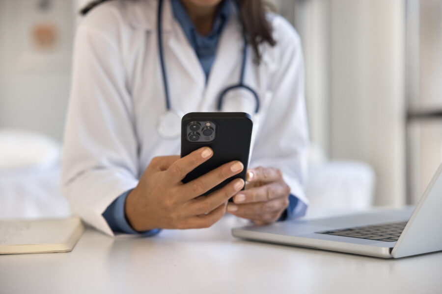 A healthcare provider holds a personal device.