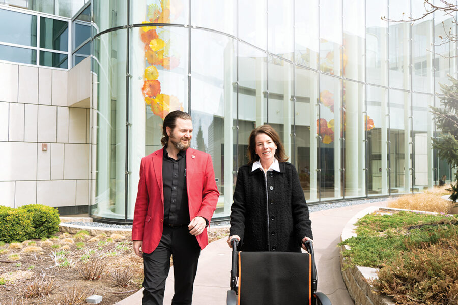 Beth Smith walks with Matthew Lunning&comma; DO&comma; medical director of the Gene and Cellular Therapy Program at UNMC&period;