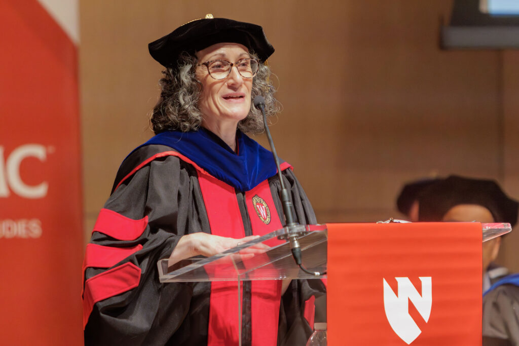 The UNMC Graduate Studies honors convocation and hooding took place Thursday May 7, 2026, at the Omaha Conservatory of Music. Here, a graduate is undergoing her traditional hooding. Karen Gould, PhD, interim dean of Graduate Studies, is speaking.