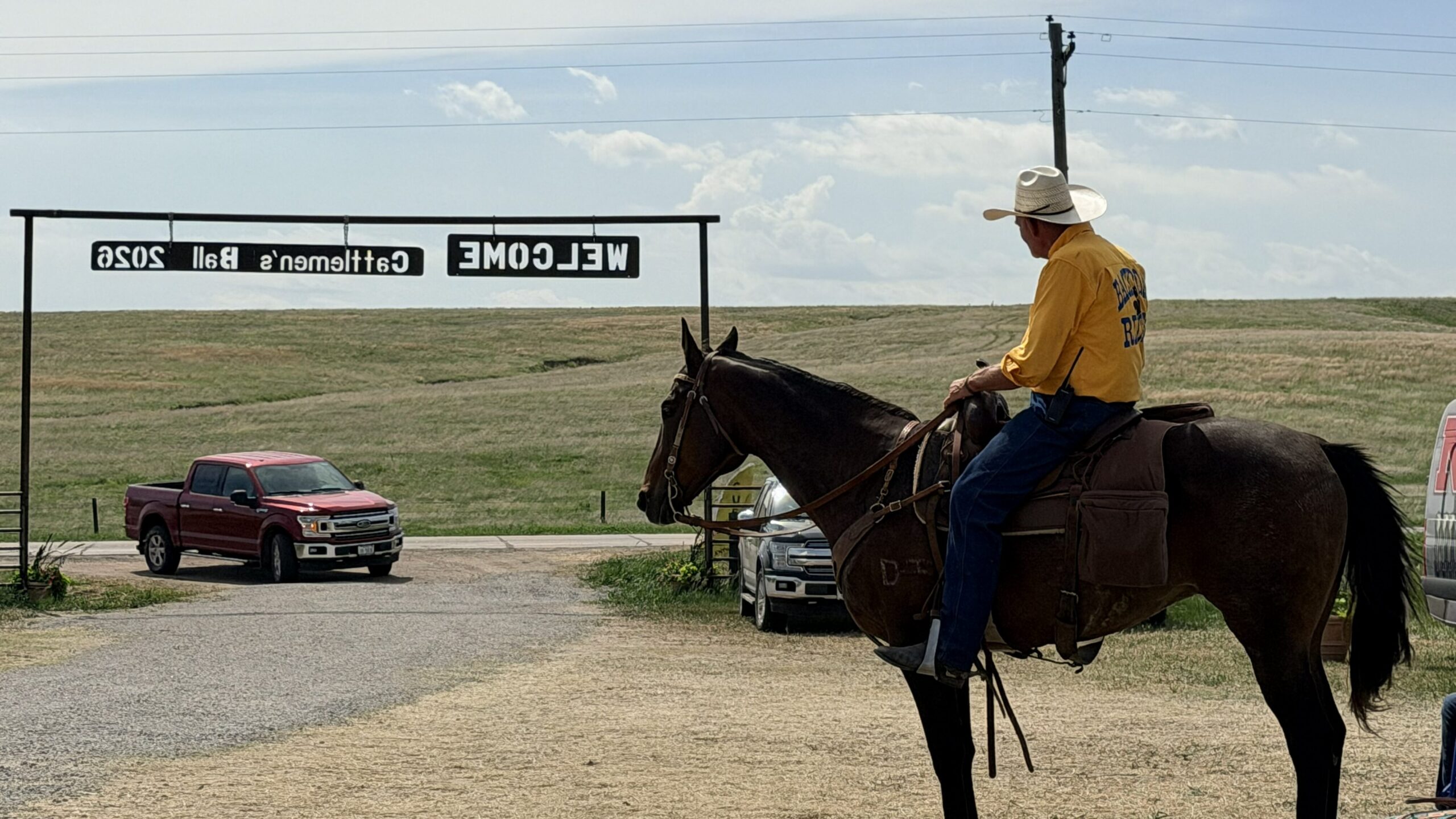 Cattlemen's Ball worker on horseback welcoming a car entering the venue