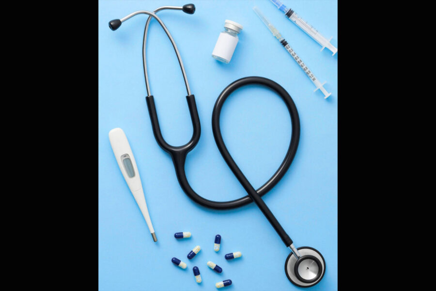 Marketing photo showing a thermometer, pills, a vial, syringes and a stethoscope