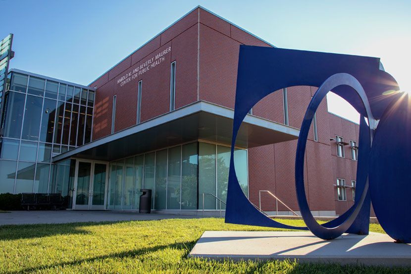 The UNMC College of Public Health Harold M. and Beverly Maurer Center for Public Health building on the left with Fletcher Benton's